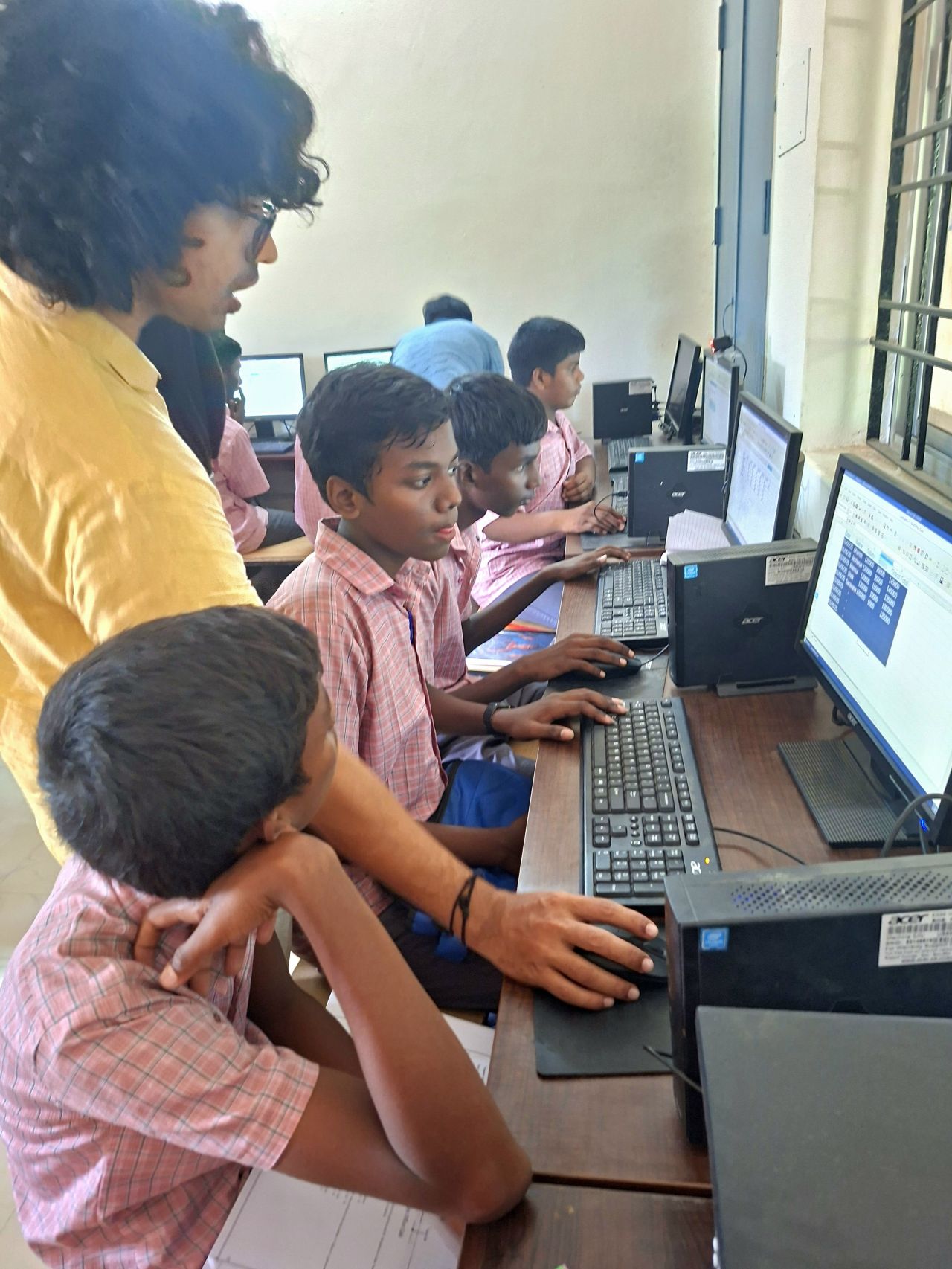 Mentors guiding students through their first hands-on computer session